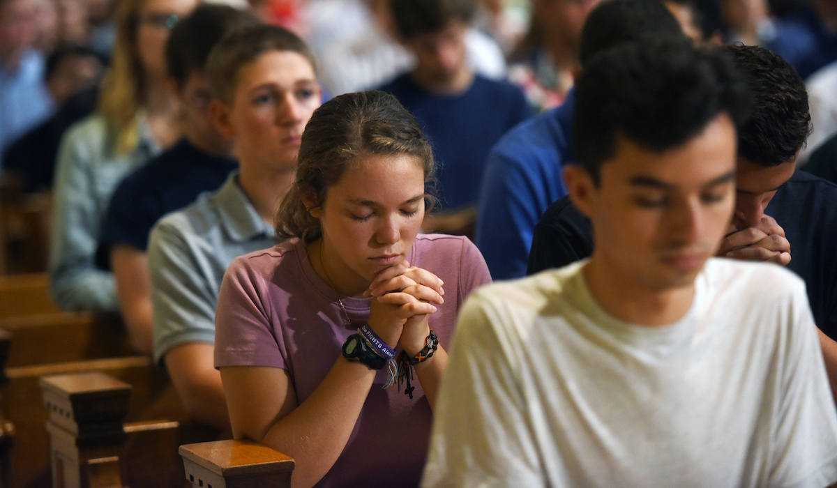 Student praying at mass